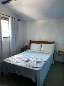 a bedroom with a bed with two towels on it at Pousada Bicho do Mar in Arraial do Cabo