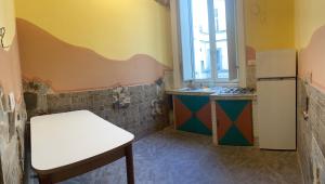 a kitchen with a white table and a refrigerator at A I R Garibaldi Apartment in Naples