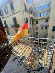 a bench on a balcony with a rainbow flag at A I R Garibaldi Apartment in Naples