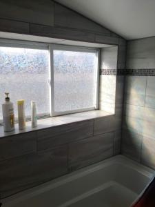 a bathroom with a bath tub and a window at Most Economical Room in Center Washington DC in Washington