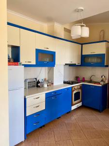 una cocina azul y blanca con armarios blancos en 1bedroom holiday apartment with amazing view Golem,Durres en Golem