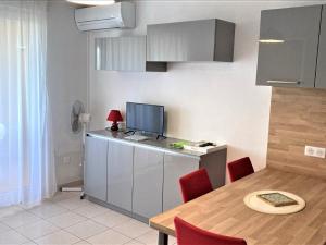 cocina con mesa con sillas rojas y TV en Studio Banyuls-sur-Mer, 1 pièce, 4 personnes - FR-1-309-210, en Banyuls-sur-Mer