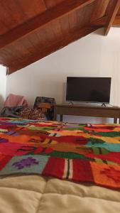 a bedroom with a colorful blanket on a bed at Los Apus Ollantaytambo in Cusco