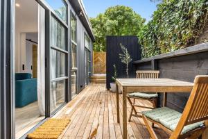 an outdoor deck with a wooden table and chairs at The Love Shack - romantic bungalow in Blairgowrie