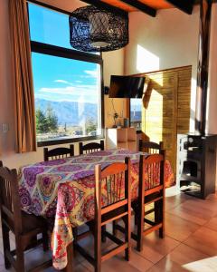 a dining room with a table and a large window at ArribadelValle - Casas de Altura in Potrerillos