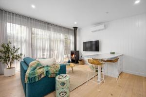 a living room with a blue couch and a table at The Love Shack - romantic bungalow in Blairgowrie