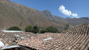 a roof of a house with mountains in the background at Los Apus Ollantaytambo in Cusco