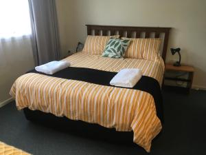 a bedroom with two beds with striped sheets at Kepplestone by the Sea - The Catlins in New Haven