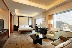 a living room with a bed a couch and a television at Lotte Hotel Seoul in Seoul