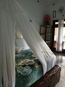 a bed with a canopy in a room at Brown Bamboo Guest house & jungle trekking orang-utan in Bukit Lawang