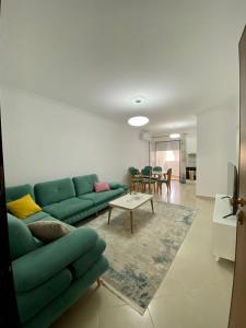 un soggiorno con divano verde e tavolo di Lungo mare holiday apartment for family a Vlorë