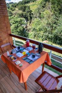 een tafel op een dek met eten erop bij Chalés Pedacim du Céu in Bueno Brandão