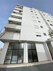 un edificio alto y blanco con ventanas laterales. en Lungo mare holiday apartment for family en Vlorë