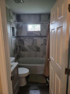 ein Badezimmer mit einer Badewanne, einem WC und einem Waschbecken in der Unterkunft 3 Bedroom Cozy Home Minutes From Tims Ford Lake in Winchester