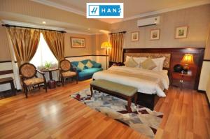 a bedroom with a bed and a couch and a table at S79 Vuon Saigon Hotel & SPA in Ho Chi Minh City