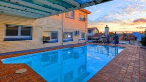 a swimming pool in front of a house at Cowra Motor Inn in Cowra