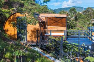 a wooden cabin with a gate and a fence at Glamping The Mountain in Guatapé