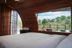 a bedroom with a bed and a large window at Glamping The Mountain in Guatapé