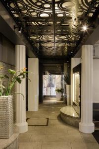 a hallway with columns and a ceiling with lights at Vino in Fukuyama