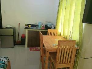 uma pequena cozinha com uma mesa de madeira e cadeiras em Condo Transient Near NAIA Airport T1234 with Unlimited WIFI v1 em Manila