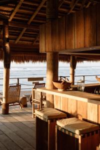 ワイカブバックにあるSumba Beach Houseのテーブルと椅子が備わる海の景色を望むレストランを併設しています。