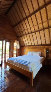a large bed in a room with a wooden ceiling at Gita Gili Bungalow in Gili Islands