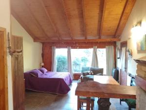 um quarto com uma cama e uma grande janela em Cabaña en el bosque em San Carlos de Bariloche