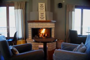 a living room with a fireplace with chairs and a table at Levanta in Megalo Chorio