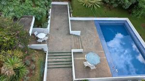 an overhead view of a swimming pool with a table and chairs at Pitaya Suítes in Cunha