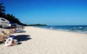 a beach with chairs and umbrellas and the ocean at Bích Ngọc Hotel Quan Lạn - Thứ 7 nhận 5 phòng trở lên in Làng Liễu