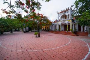 a building with a red brick sidewalk in front of a building at Bích Ngọc Hotel Quan Lạn - Thứ 7 nhận 5 phòng trở lên in Làng Liễu +21 photos