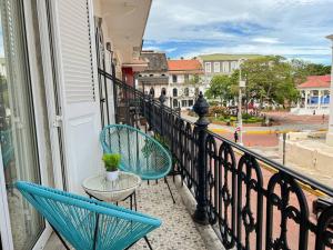 two blue chairs and a table on a balcony at Apartamento en el Corazón de Casco Viejo Panamá 12 in Panama City
