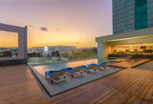 una piscina en la azotea con tumbonas en un edificio en Hyatt Centric San Salvador, en San Salvador
