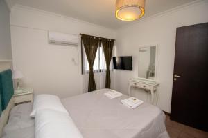 a bedroom with a white bed with two towels on it at A & P in Santa Fe