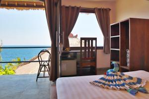 1 dormitorio con 1 cama y vistas al océano en Selang Resort, en Amed