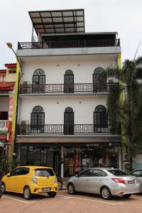 two cars parked in front of a building at Hotel Decentraland Kuala Terengganu in Kuala Terengganu