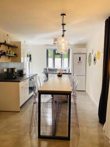 a kitchen with a table and chairs in a room at LES CERISIERS BEACH RESIDENCE-Luxury 3Bd, Pool, Big Terrasse, 50mts from beach in Flic-en-Flac