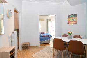 een woonkamer met een tafel en stoelen bij Venias Two-Bedroom apartment Kallimarmaro and Zappeio area in Athene