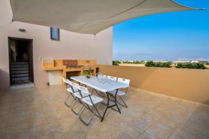 a dining room with a white table and chairs at Luxury Xenos Villa 2 With 4 Bedrooms , Private Swimming Pool, Near The Sea in Tigaki