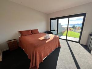 a bedroom with a bed and a large window at Starry Vista-Alpha in Lake Tekapo