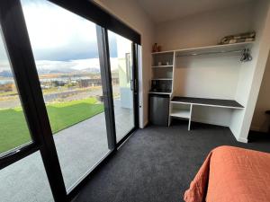 a bedroom with a bed and a large window at Starry Vista-Alpha in Lake Tekapo