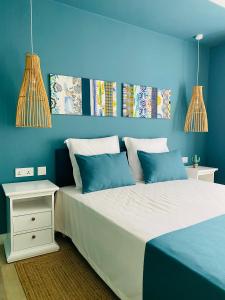 a blue bedroom with a large bed with blue walls at LES CERISIERS BEACH RESIDENCE-Luxury 3Bd, Pool, Big Terrasse, 50mts from beach in Flic-en-Flac