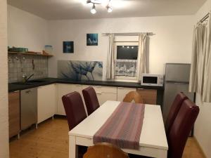 a kitchen with a white table and chairs and a table and a microwave at Ferienhaus Marktl in Gnesau