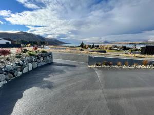 a road with a retaining wall and a stone wall at Starry Vista-Beta in Lake Tekapo