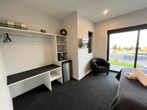 a room with a bed and a desk and a window at Starry Vista-Beta in Lake Tekapo