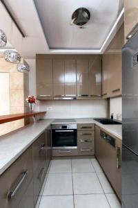 una cocina con armarios de madera y electrodomésticos de acero inoxidable en Apartment 32, en Belgrado