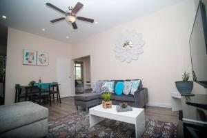 a living room with a couch and a ceiling fan at RayneBow Chateau - Chic City Getaway in Port-of-Spain