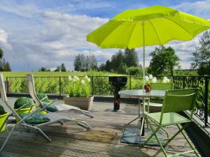 eine Terrasse mit einem Tisch, Stühlen und einem Sonnenschirm in der Unterkunft Le Relais des Fagnes in Sart-lez-Spa