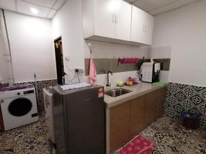 a small kitchen with a sink and a refrigerator at Fastbook Ferringhi SoHo unit 8pax in Batu Ferringhi