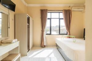 a bedroom with two beds and a window at Urbanview Hotel Nugraha Palembang by RedDoorz in Palembang
